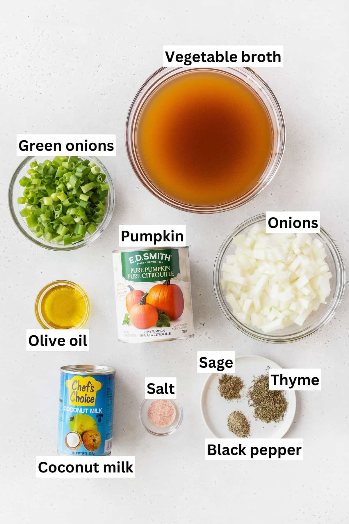 Ingredients needed to make vegan pumpkin bisque soup measured out into bowls on a white table with text overlay.