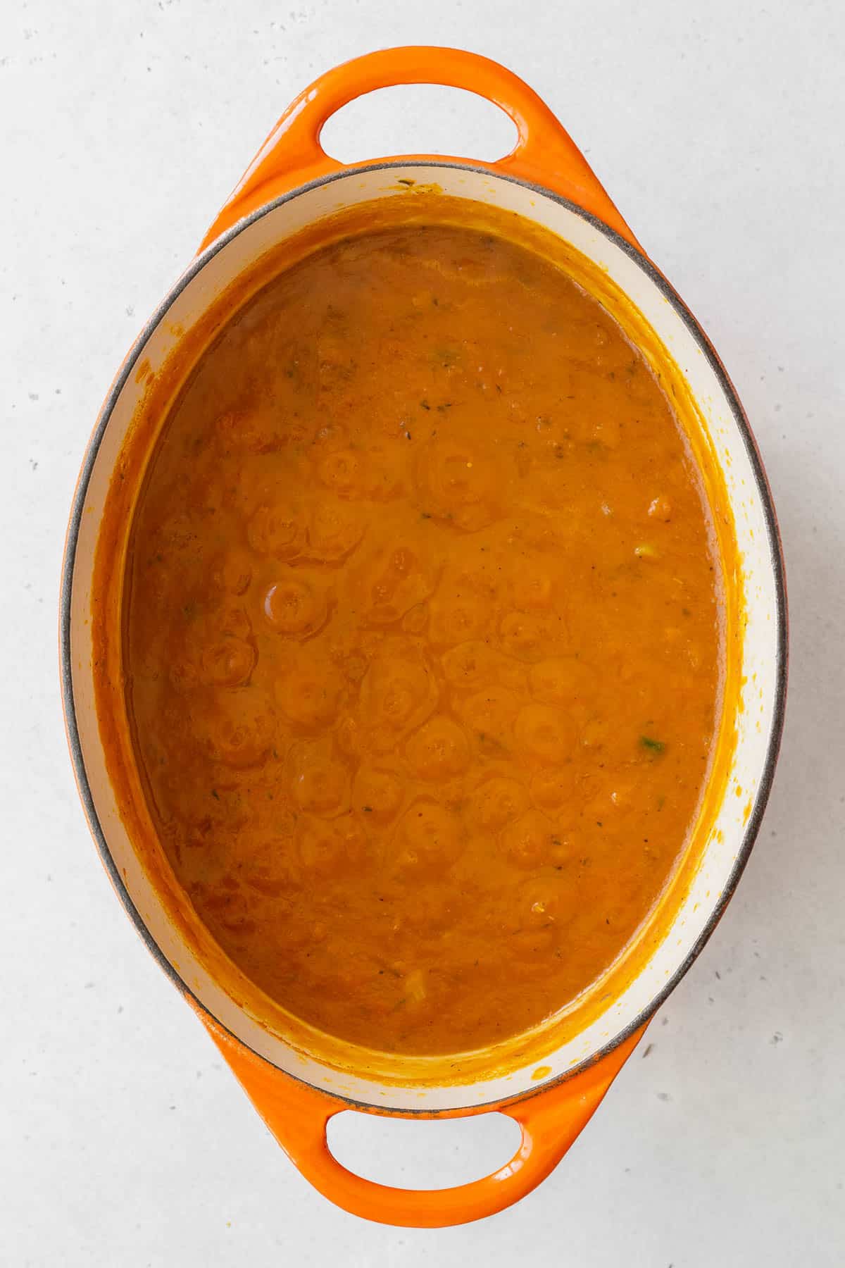 Pumpkin puree, veggie broth, and garlic powder added to the pot with the onions and spices.