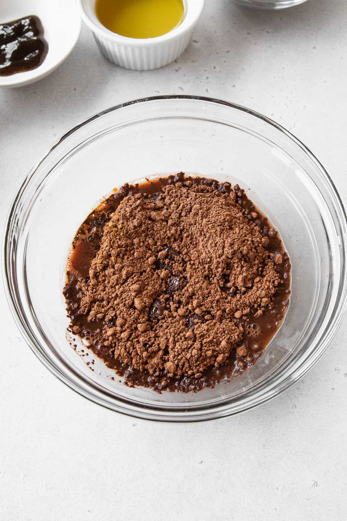 Cocoa powder being bloomed in a glass bowl with hot water.