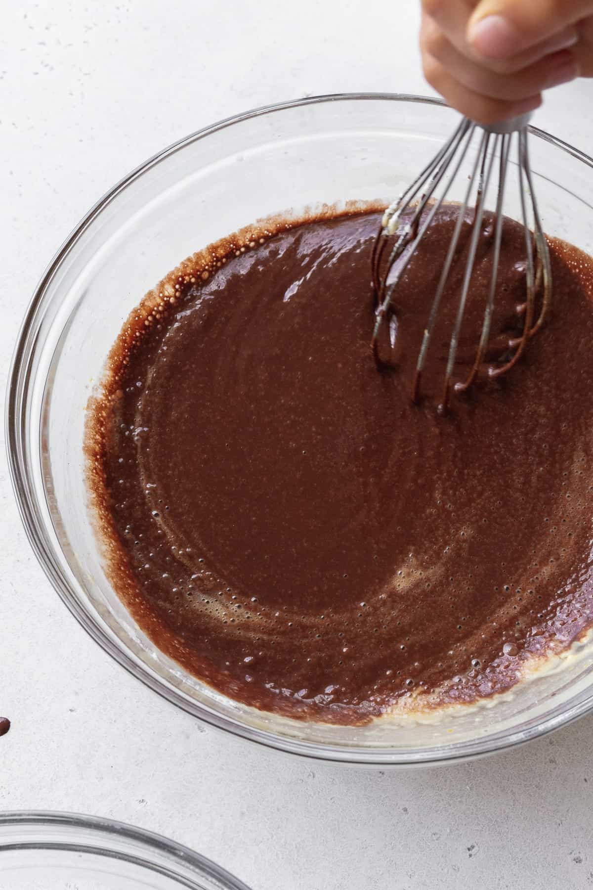 Chocolate cupcake batter being mixed with a whisk.
