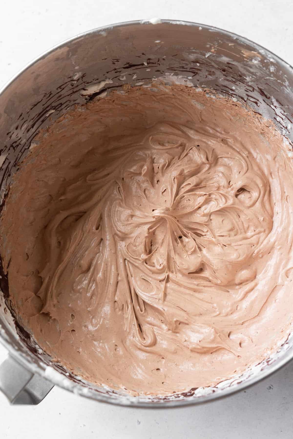 Chocolate cream cheese frosting in a metallic bowl.