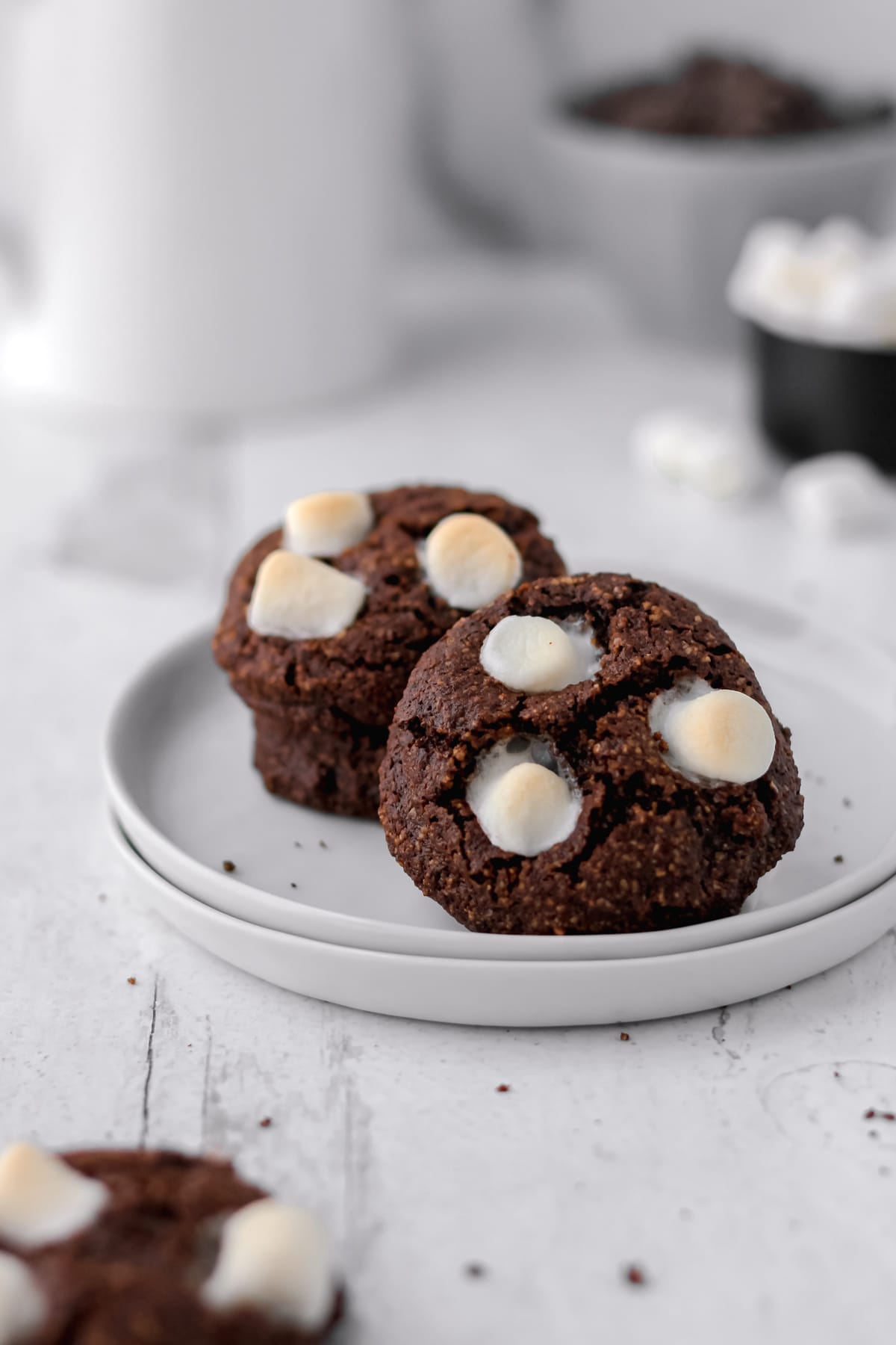 Hot cocoa cookies on a stack of small white plates.
