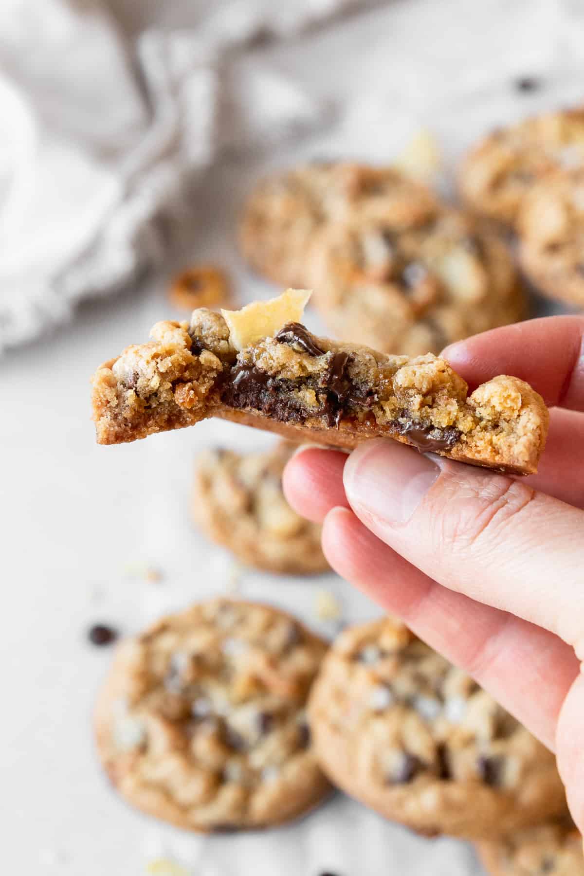 A hand holding a half eaten kitchen sink cookie.