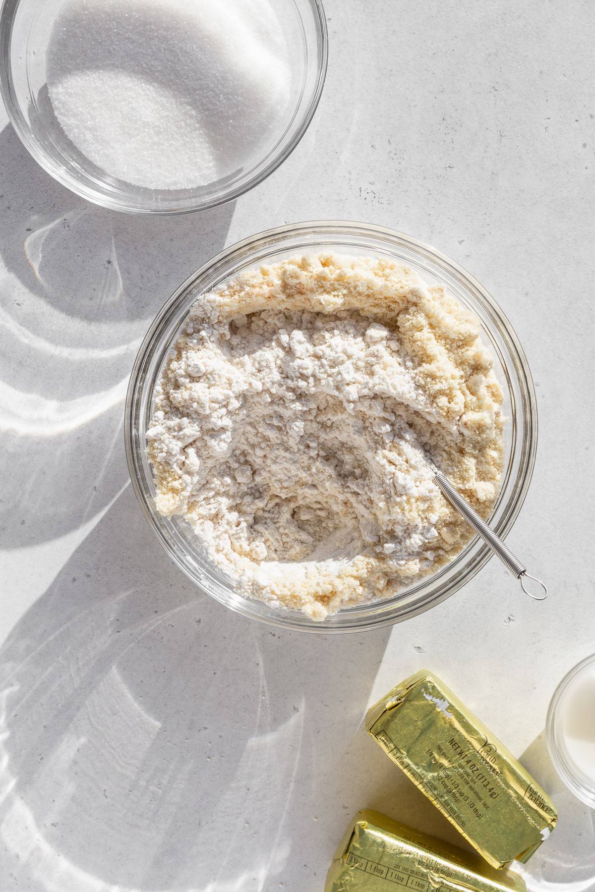 Dry ingredients mixed together in a glass bowl on a light grey surface.