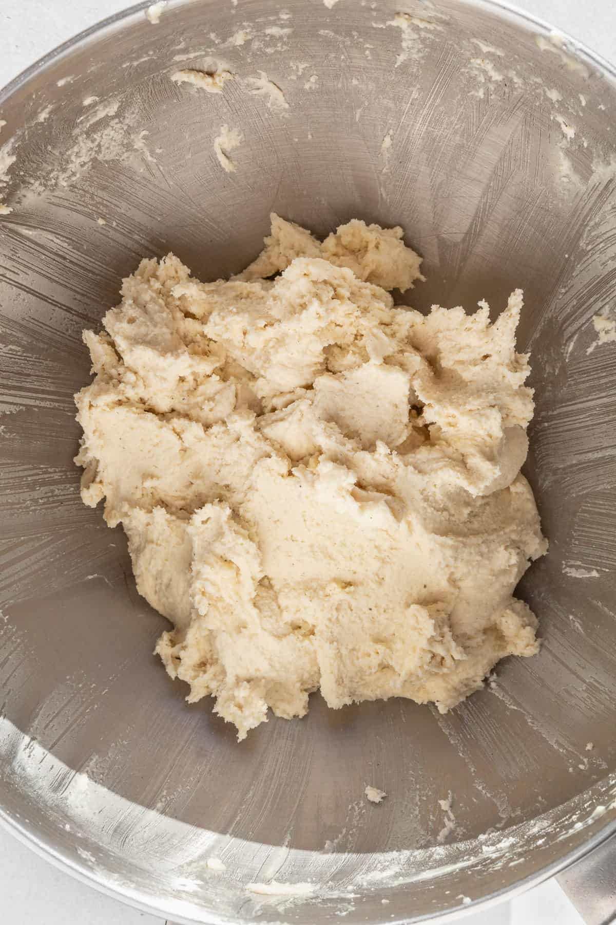 Gluten free sugar cookie dough in a large metallic bowl.