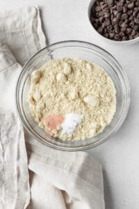 Dry ingredients in a glass bowl with salt on top.