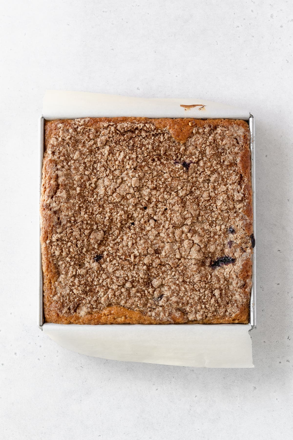 Baked blueberry sour cream cake in a square pan.