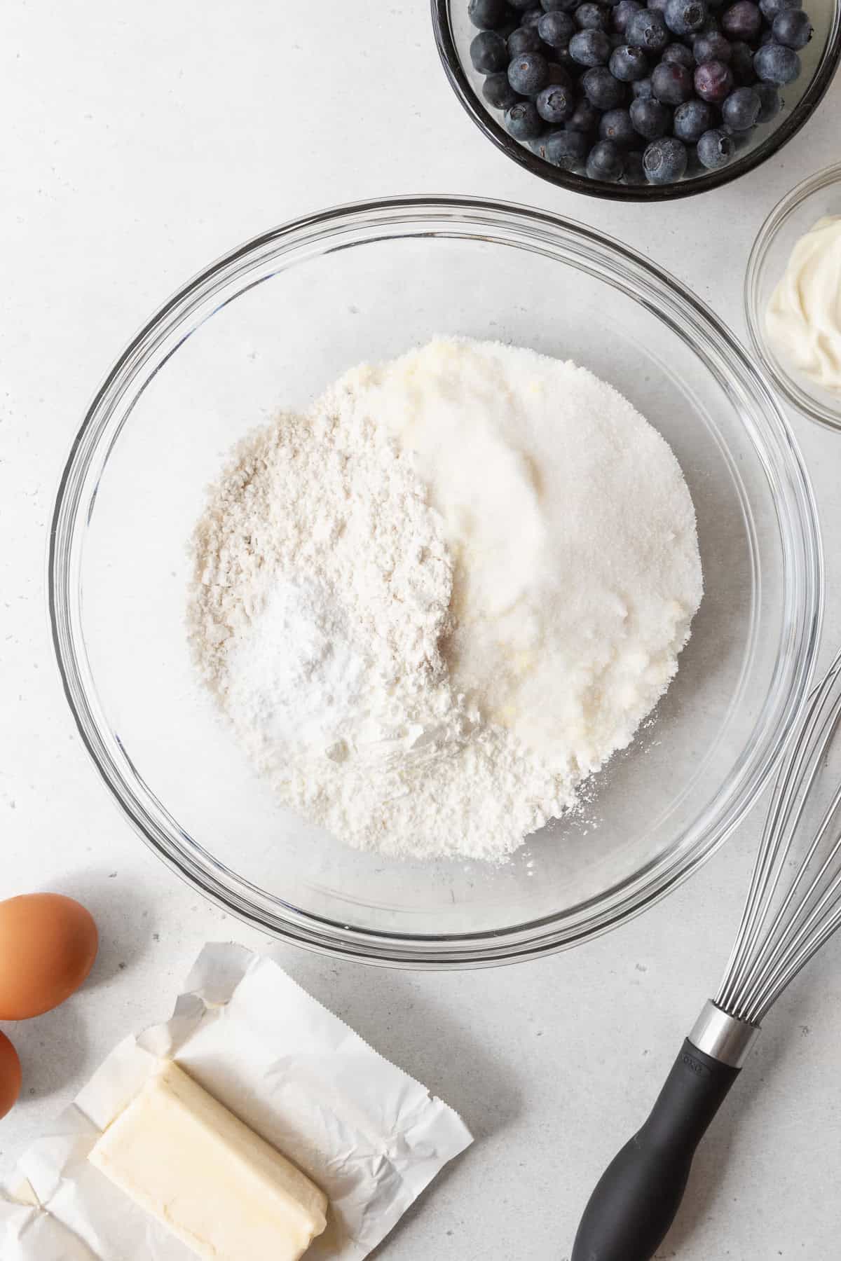 Dry ingredients of blueberry coffee cake in a large glass bowl.