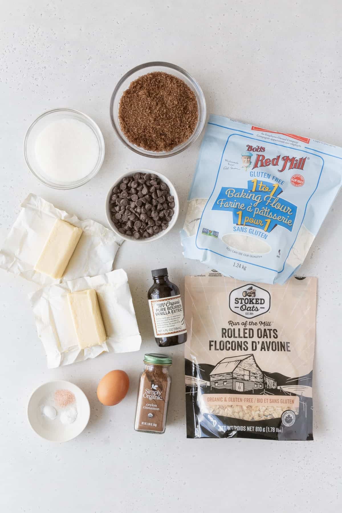 Ingredients to make gluten free oatmeal cookies laid out on a grey surface.