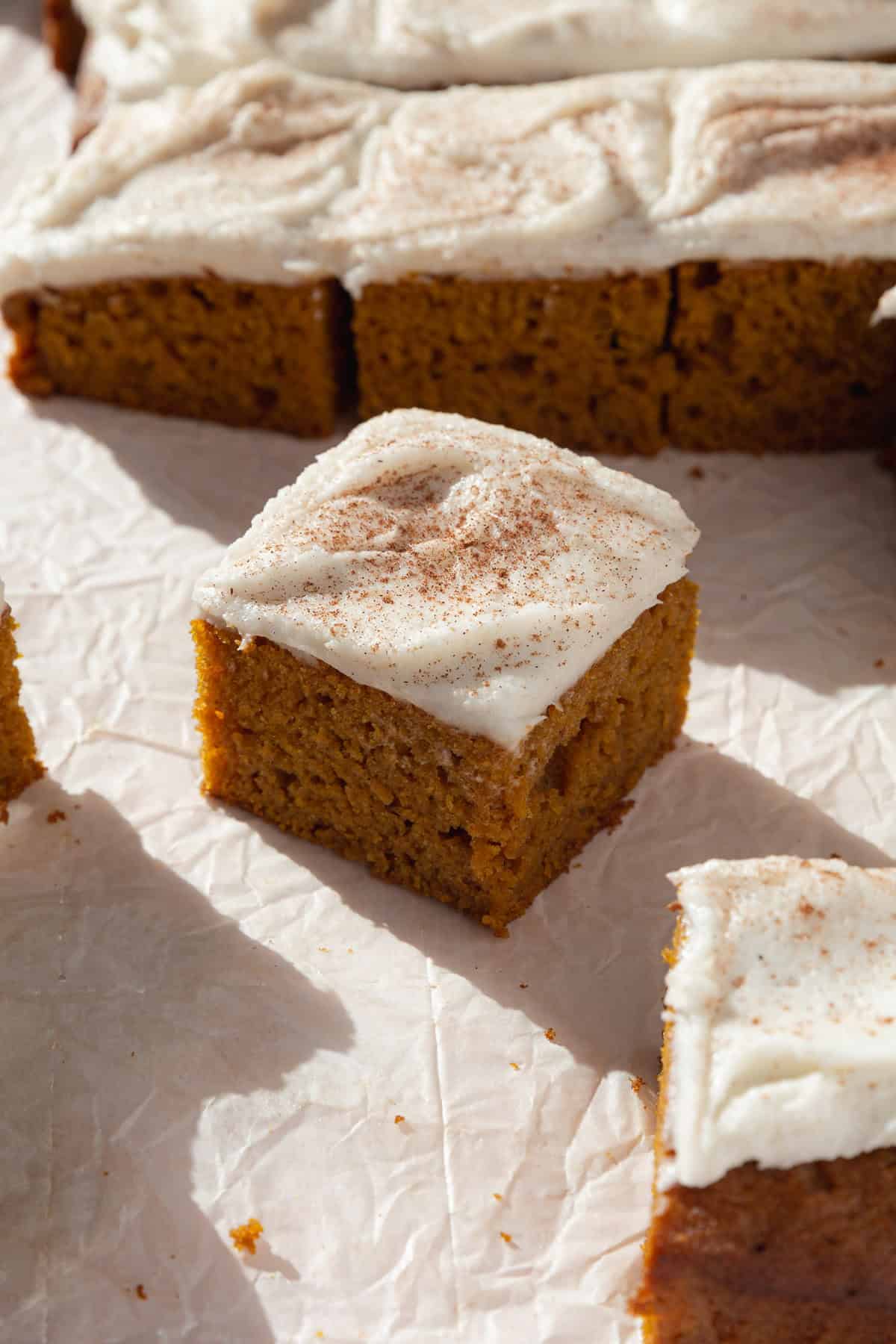 A slice of pumpkin bars with cream cheese frosting.