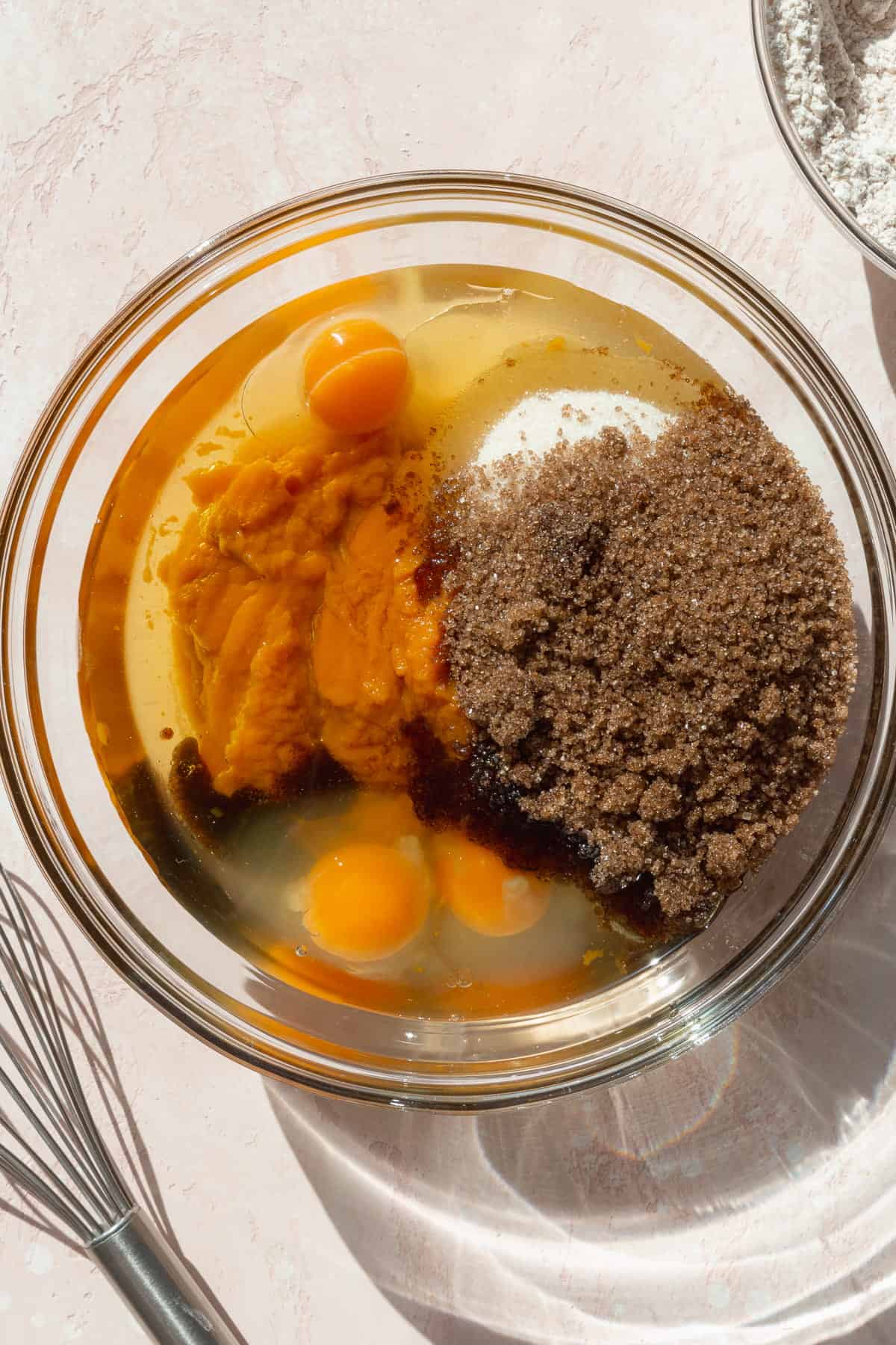 Pumpkin purée, eggs, oil, granulated and brown sugar in a large glass bowl.
