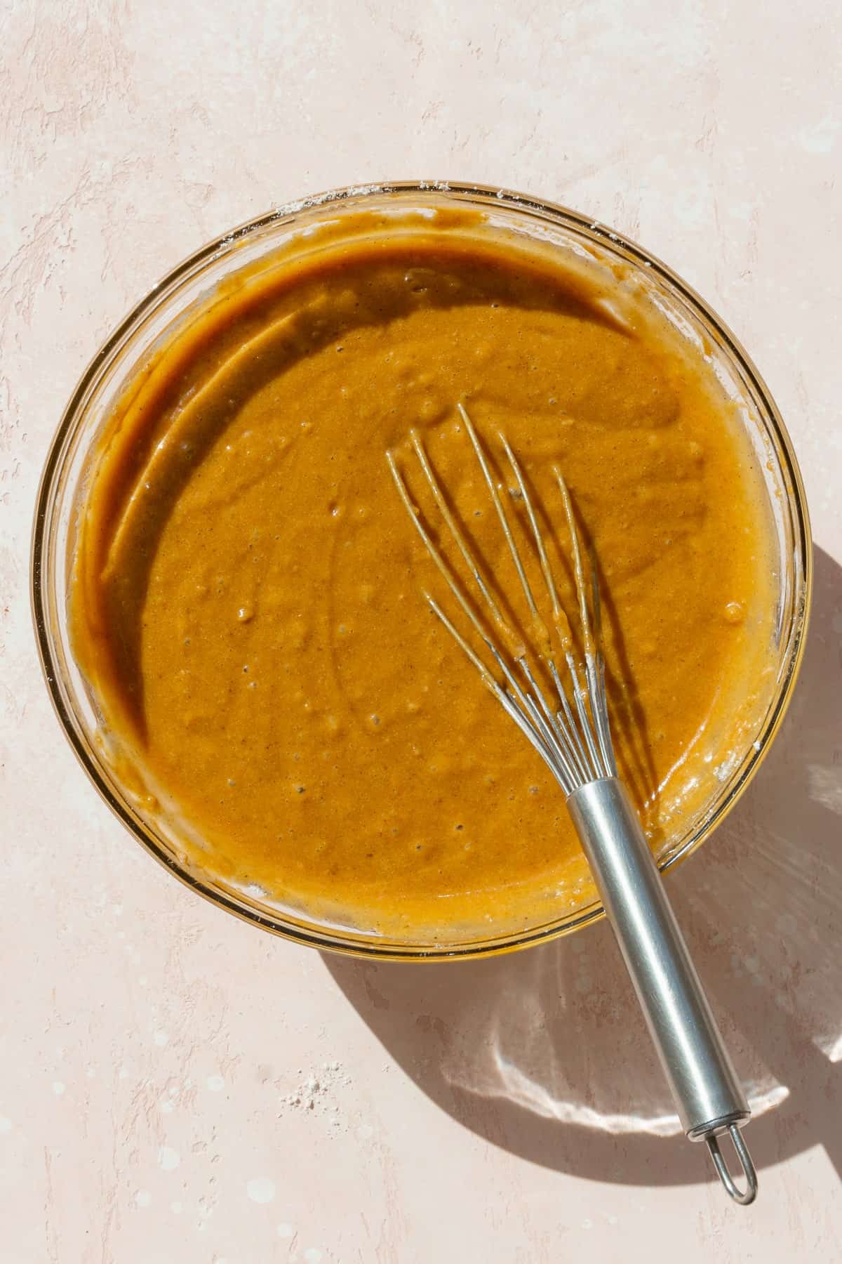 Pumpkin bar batter in a bowl with a wire whisk.