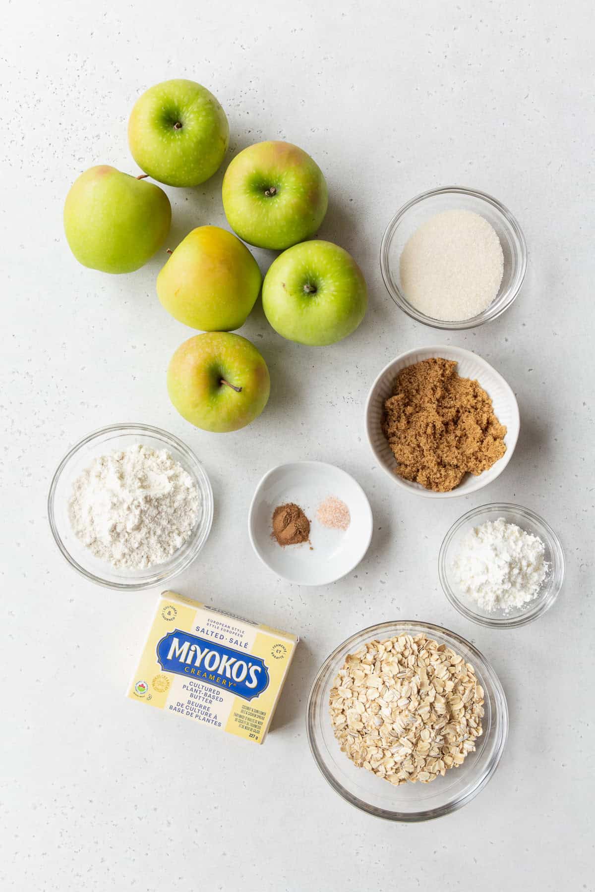 Ingredients to make gluten-free apple crisp on a light grey surface