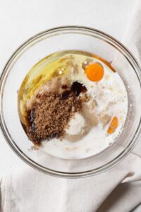 A glass bowl with wet ingredients for a muffin recipe.