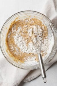 Dry ingredients being whisked into wet ingredients.