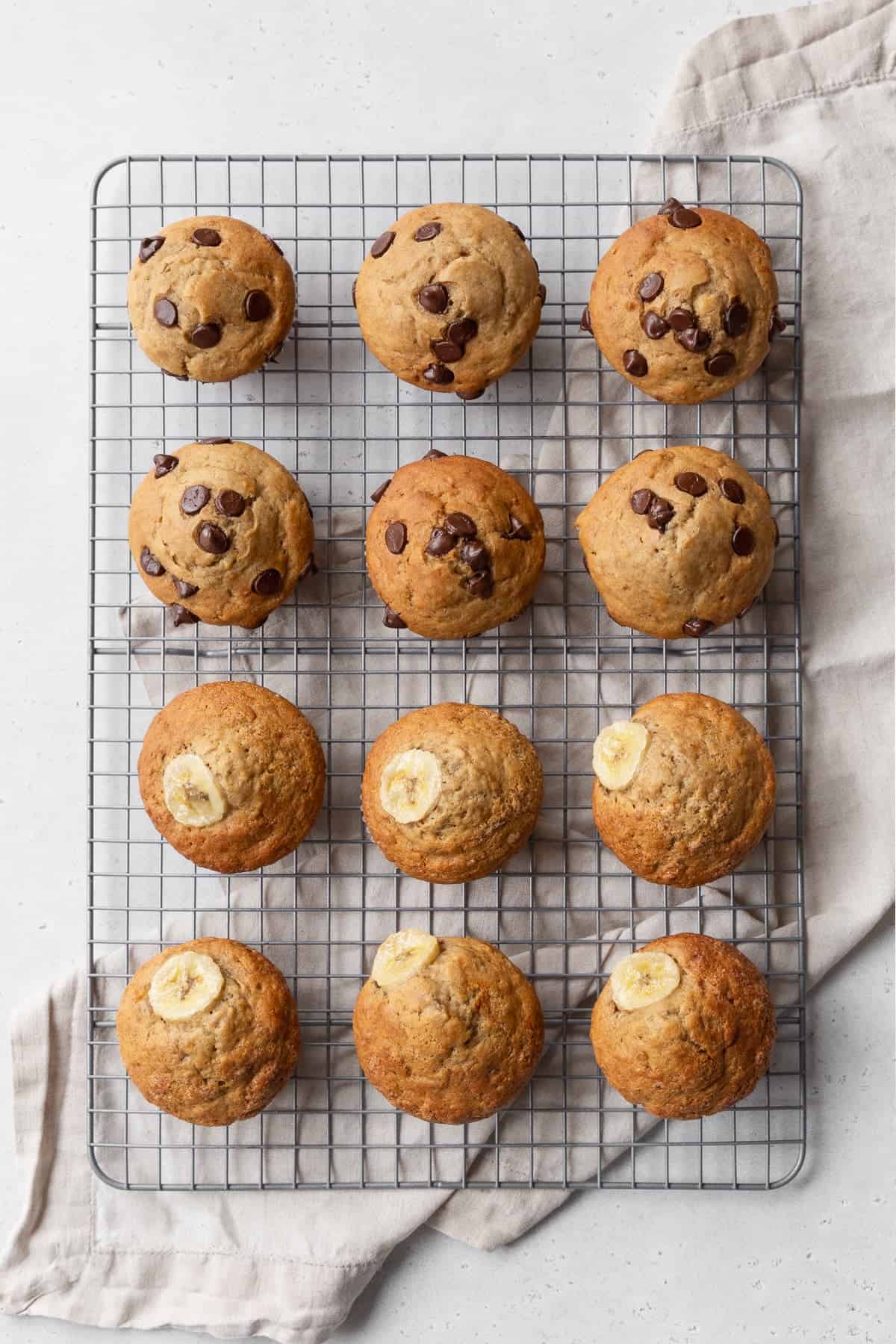 Twelve banana muffins cooling on a wire rack.