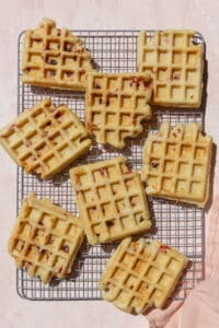 Cooked waffles on a wire rack.