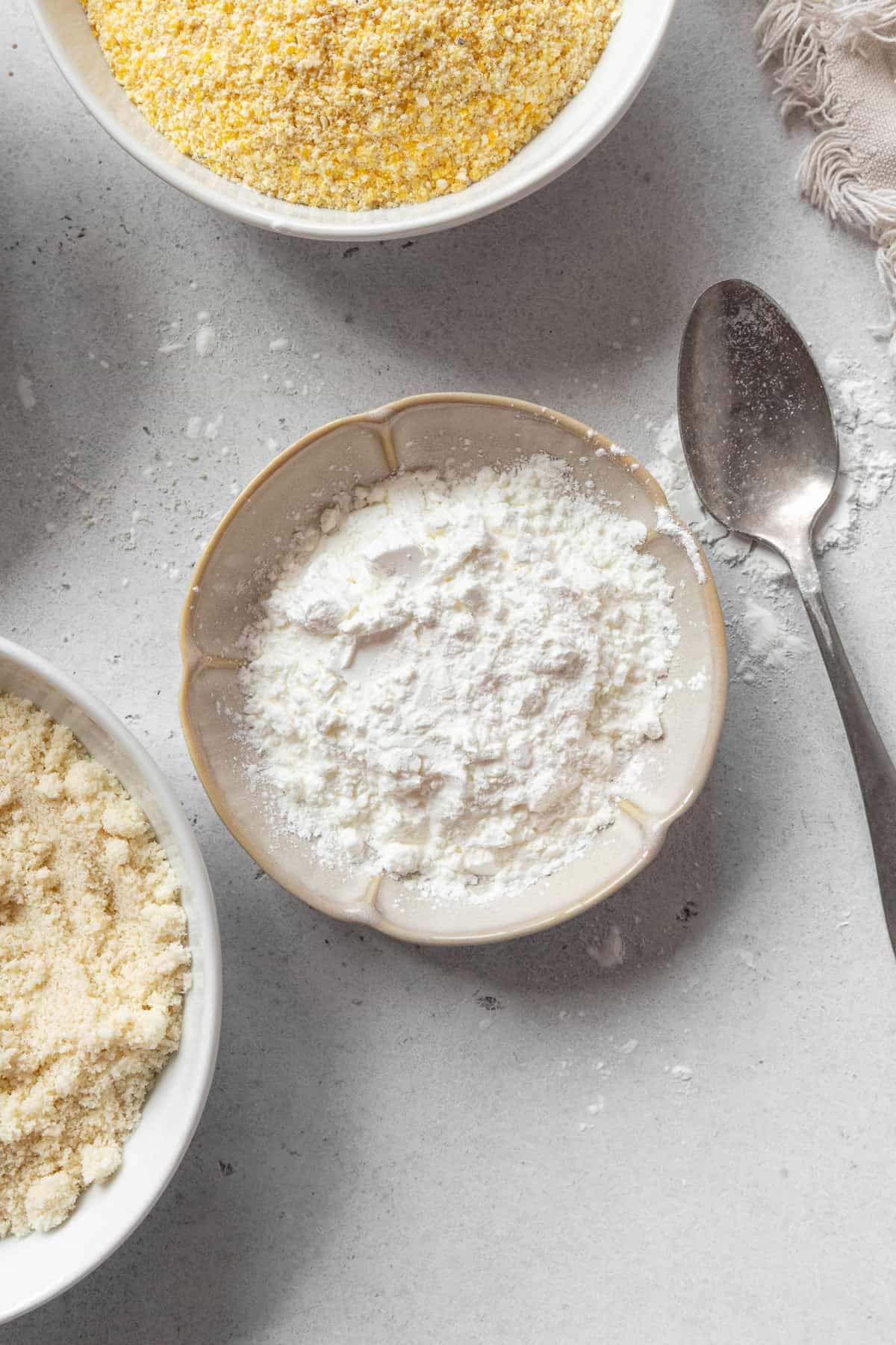 A small dish of cornstarch with a spoon next to it.