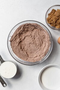 Dry ingredients for chocolate cake in a glass bowl.