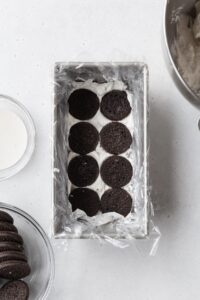 Chocolate cookies in a loaf pan with cream underneath.