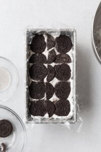 Chocolate cookies on top of cream to build an icebox cake.