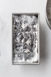 Ice box cake wrapped in plastic, ready to be chilled.