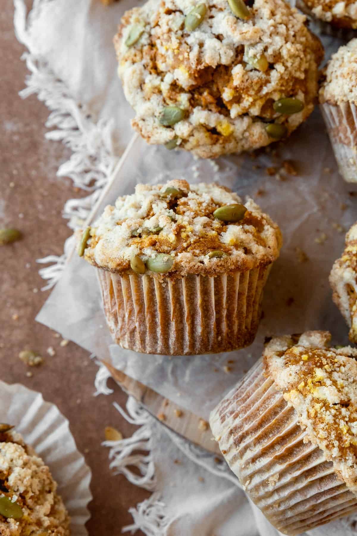 A pumpkin streusel muffin on its side with more muffins around it.