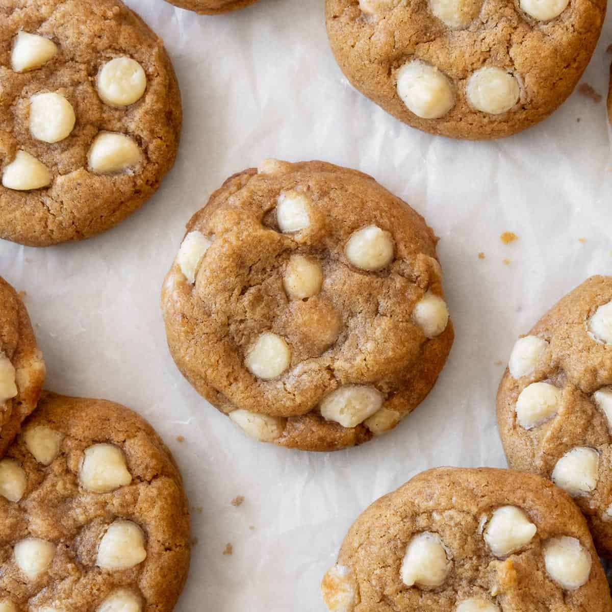Gluten free pumpkin cookies with white chocolate chips on parchment paper.