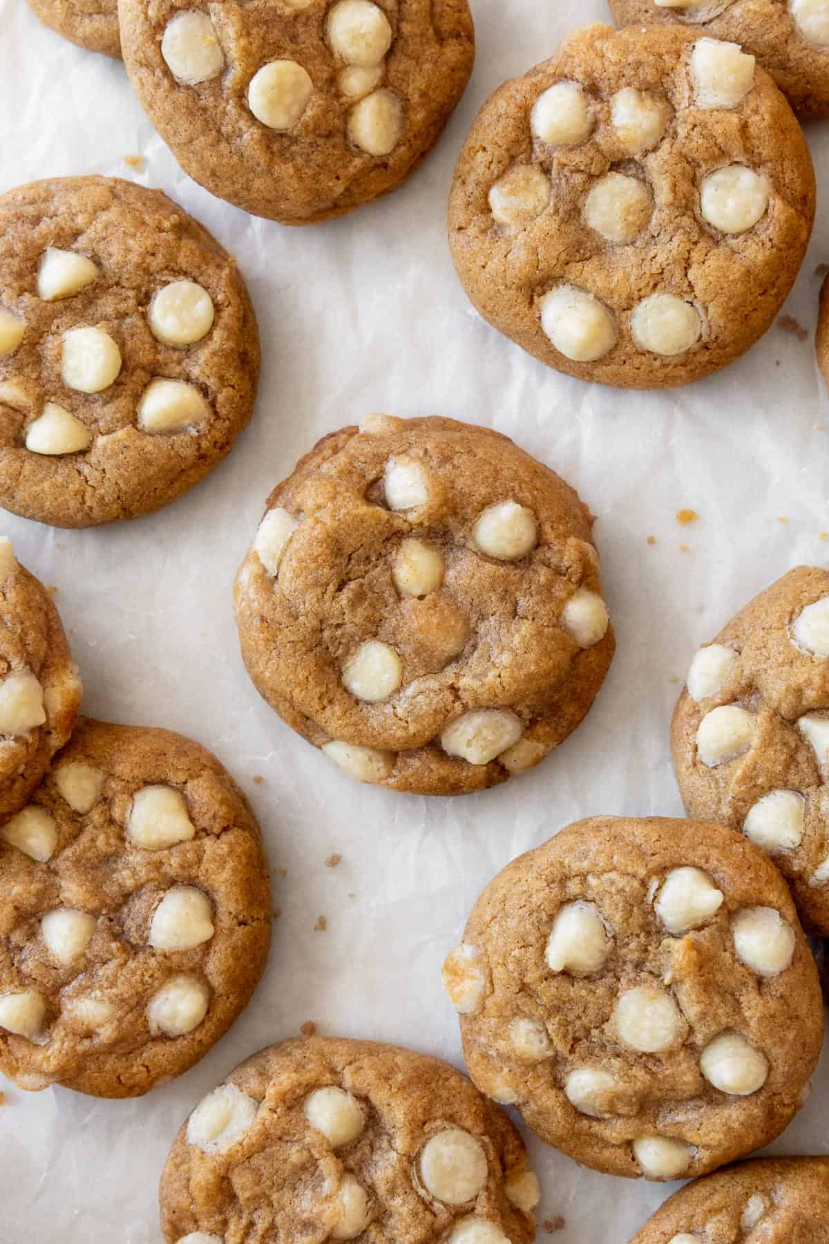 Gluten free pumpkin cookies with white chocolate chips on a piece of parchment paper.